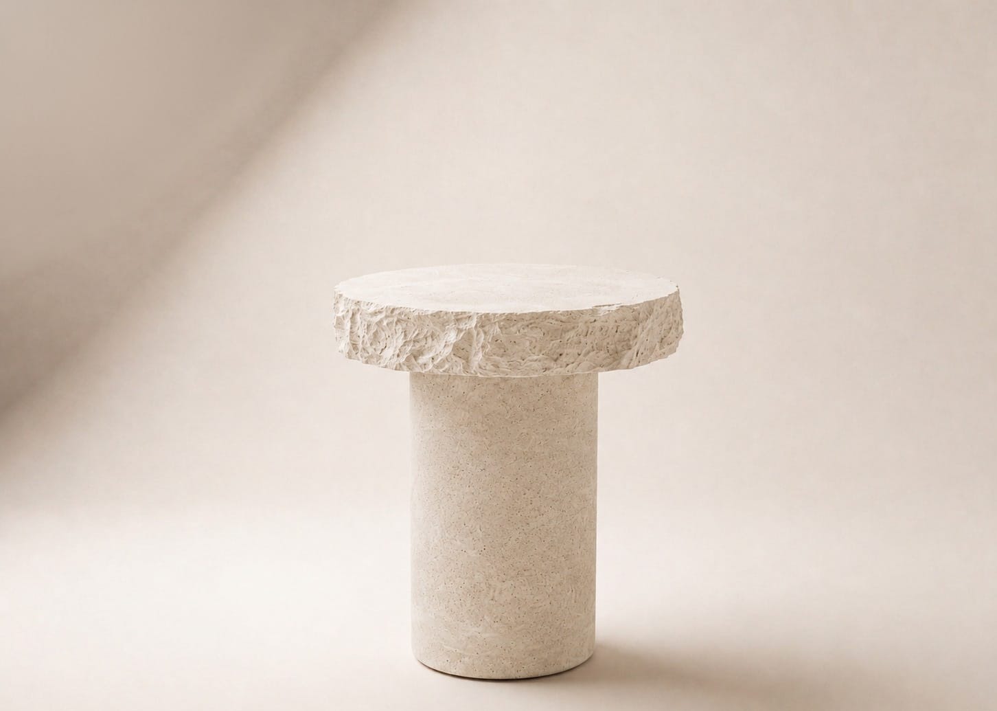CIVITAS LÁPIS CLIFF side table studio photograph, raw-fractured circular top on a cylindrical concrete drum.